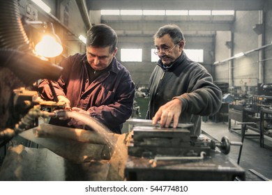 Two Men Doing Induction Hardening In A Factory 