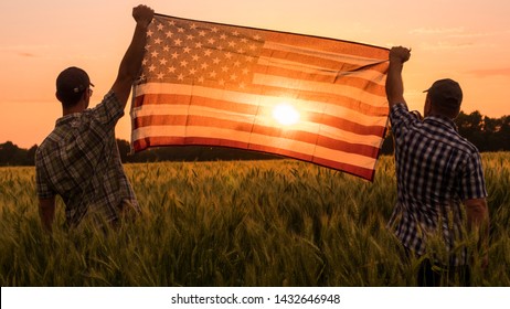 Two men energetically raised the US flag in a picturesque field of wheat