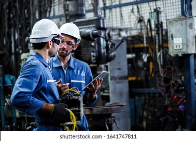 Two men engineer talking in modern factory. Production line machine and setting it for work. - Powered by Shutterstock