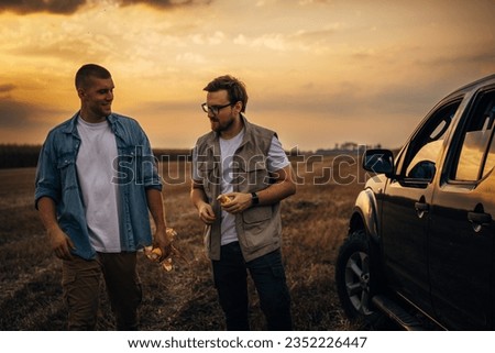 Two men are in the field together.