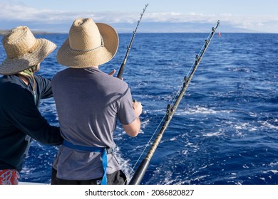 Two Men Fishing On A Boat. Fishing Trip While On Vacation. Deep Blue Water, Nice Sky. 