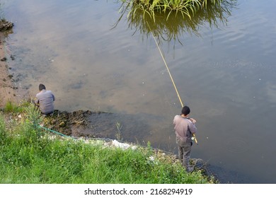 Two Men Fishing On The Lake, Rear View