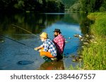 Two men friends anglers fishing. Flyfishing angler makes cast, standing in river water. Old and young fisherman.