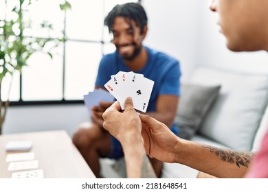 Two Men Friends Playing Poker Cards Sitting On Sofa At Home