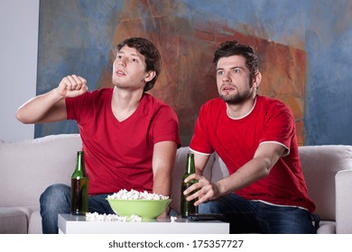 Two Men Friends Watching A Movie At Home Eating Popcorn And Drinking Beer