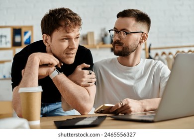 Two men, a gay couple, lean in towards a laptop screen, engrossed in their fashion design collaboration. - Powered by Shutterstock