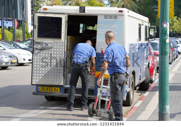 Two men of the guards of the Truck of Brink\'s\
Company put the money bags in the car. guards transporting money.\
guards with guns transporting money. 11 November 2018. Tel Aviv.\
Israel.