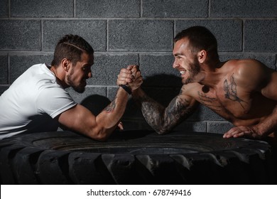 Two men with hands clasped in arm wrestling challenge. Bodybuilding concept