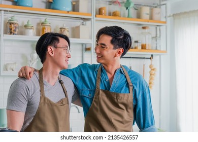 Two men Happy cooking together at home. LGBTQ people are hugged and make eye contact happy. Asian gay couple happy and having romantic moment together in the kitchen. Friendship between friends.