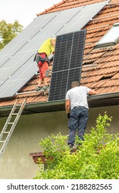 Two men installing new solar panels on the roof of a private house. Renewable energy concept. Iinstallation of photovoltaics. Energy saving. - Shutterstock ID 2188282565