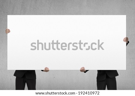 Two men lifting blank board indoor
