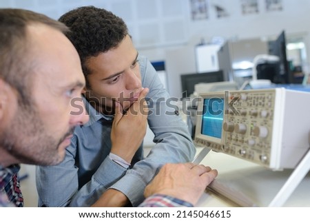 two men looking at radio frequency screen