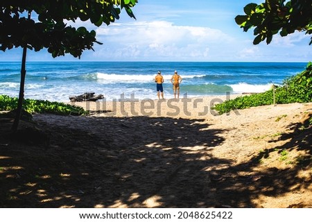 Two men looking at the see on the beach