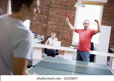 Two Men In Office Space Playing Ping Pong