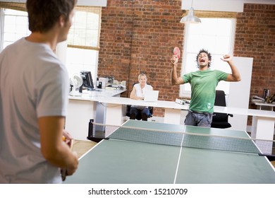 Two Men In Office Space Playing Ping Pong
