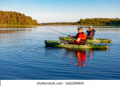 
Two Men On Kayaks Fish In Sunny Weather On A Lake
