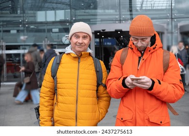 two men in orange jackets at station, Passengers with backpacks wait for train at station Berlin Hauptbahnhof, concept boarding travelers in cars, hustle and bustle train travel, Berlin, Germany
