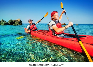 Two men paddle a kayak on the sea. Kayaking on island - Shutterstock ID 198556994