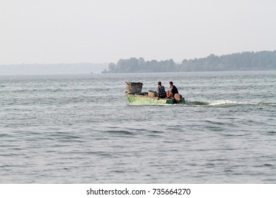 Two Men Are Sailing On An Old Motor Boat. Social Problems Illegal Fishing And Border Crossing.