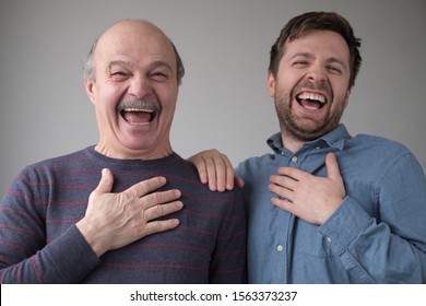 Two men and son laughing on their friend joke having a good mood. Positive facial emotion.