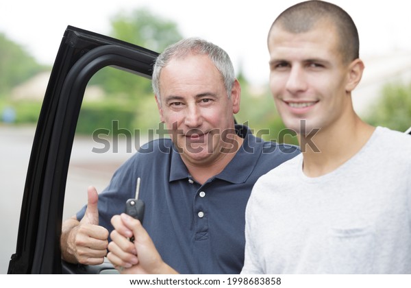 two men standing by\
car