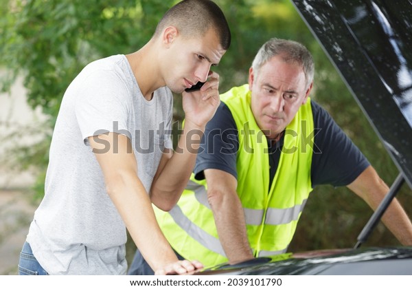 two men standing by the\
car