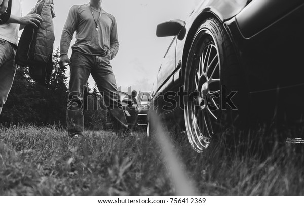 Two men are standing by the\
car