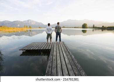 Two Men Standing On A Pier.