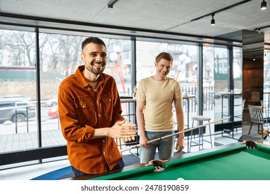 Two men strategizing and playing pool in a coworking space, reflecting a modern business lifestyle with a startup team vibe. - Powered by Shutterstock