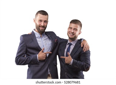 Two Men In Suits Hugging And Point The Finger At Each Other
