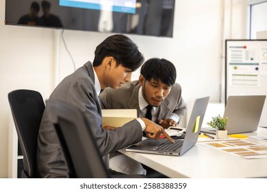 Two men in suits are looking at a computer screen with graphs and charts. They are discussing the data and making decisions based on the information presented. The atmosphere is serious and focused
