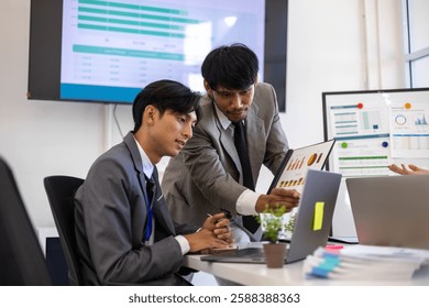 Two men in suits are looking at a computer screen with graphs and charts. They are discussing the data and making decisions based on the information presented. The atmosphere is serious and focused
