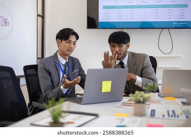 Two men in suits are looking at a computer screen with graphs and charts. They are discussing the data and making decisions based on the information presented. The atmosphere is serious and focused
