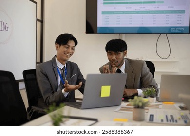 Two men in suits are looking at a computer screen with graphs and charts. They are discussing the data and making decisions based on the information presented. The atmosphere is serious and focused
