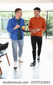 Two men talking while walking in living room.