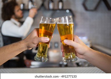 Two men toasting a glass of beer in bar - Shutterstock ID 491277133