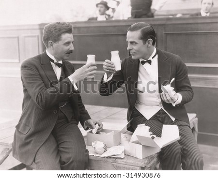 Two men toasting with milk bottles