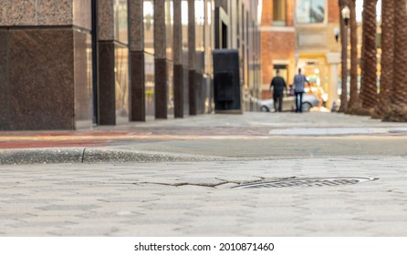 Two Men Walk Down A City Street Sidewalk During The Sunset Golden Dinner Hour. Low Angle Image With Copy Space Selective Focus