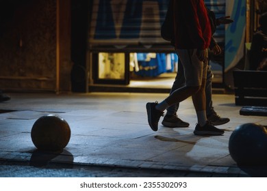 Two men walking down sidewalk in evening in front of closing clothing store. Walking in summer, evening city life