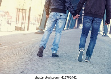 Two Men Walking And Holding Hands