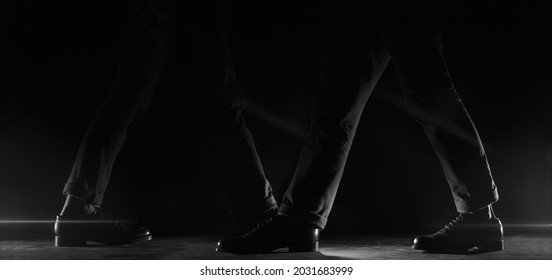 Two Men Walking In Opposite Angles Shot From Below, Focusing Only On His Footsteps, Are Given A Dark And Light Touch To The Side Of The Image, Aiming For All Eyes To Focus On His Shoes.