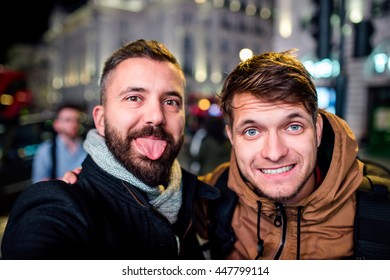 Two Men Walking In The Streets Of London At Night