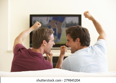 Two Men Watching Widescreen TV At Home