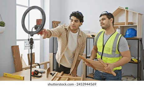 Two men working together in a bright carpentry workshop using tools and building wooden furniture. - Powered by Shutterstock