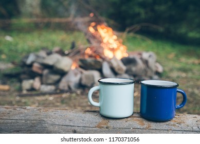 two metal cups with tea. fire on background. union with nature - Powered by Shutterstock