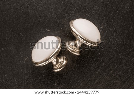 Two metal drawer handles on slate stone, furniture accessories, macro, top view.	
