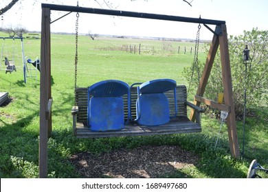 Two Metal Lawn Chairs On A Lawn Swing