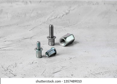 Two Metal Pop Rivet Fasteners Of Different Size, On Grey Cement Background. Horizontal With Copy Space For Text And Design. Ingeneering.