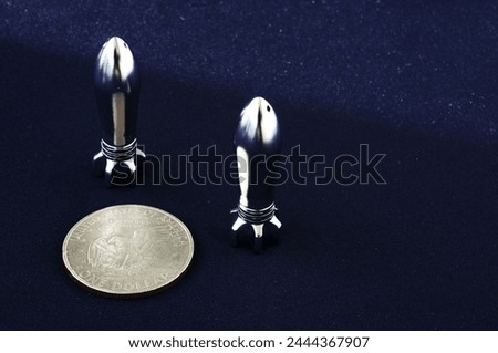 Two metal rockets on a black background. Takeoff, idea, metal. Missile. Items isolated on a black background. No war. Projectile, bullet, slug, pellet, pill, packet, plug, ball
