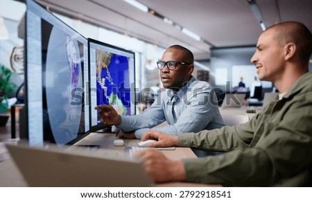 Two Meteorologists Analyze Climate Data On Computers Predicting Hurricane Impact.
